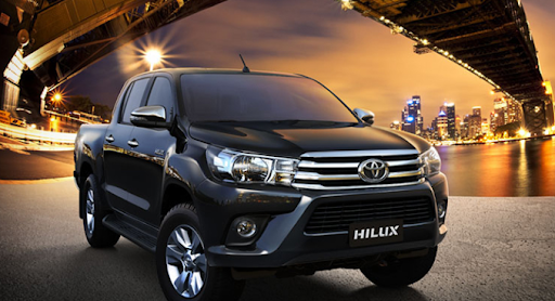 Gambar menunjukkan sebuah mobil Toyota Hilux sedang parkir di malam hari