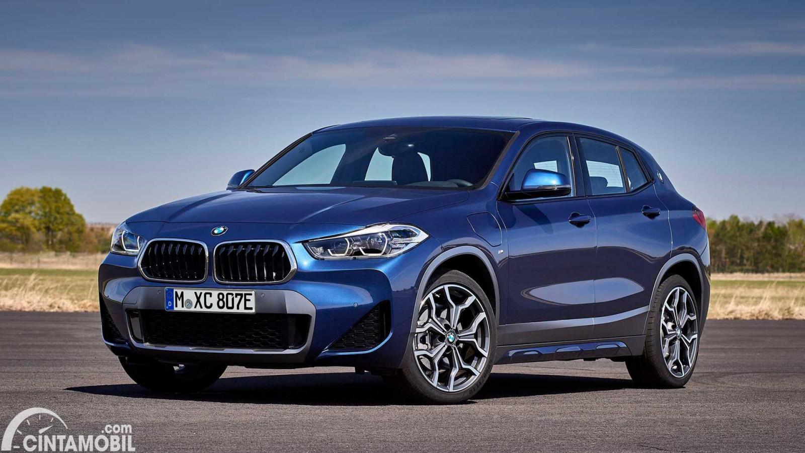 Gambar menunjukkan sebuah mobil BMW X2 berwarna biru dilihat dari sisi depan