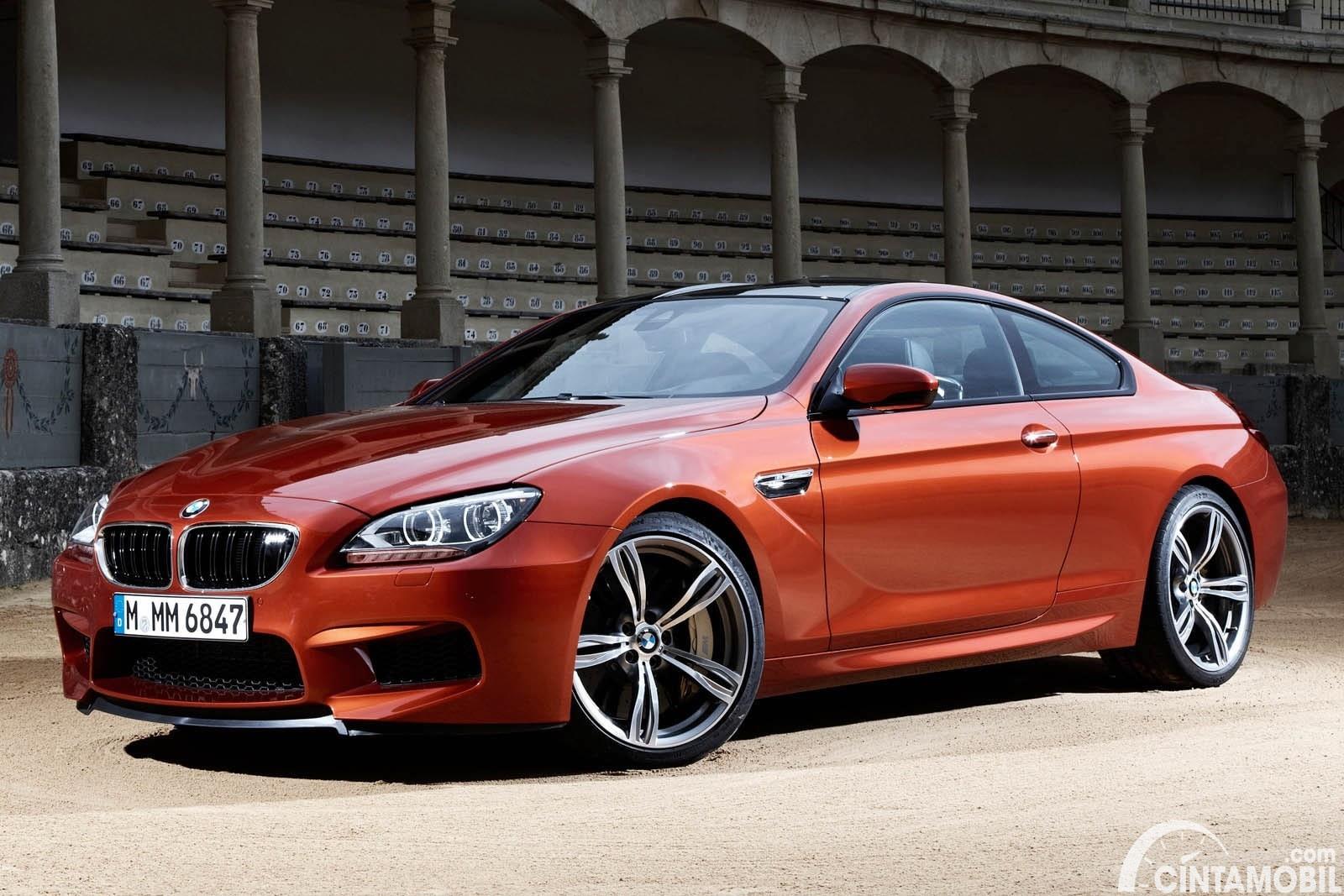 Gambar menunjukkan mobil BMW M6 2 door berwarna orange dilihat dari sisi depan