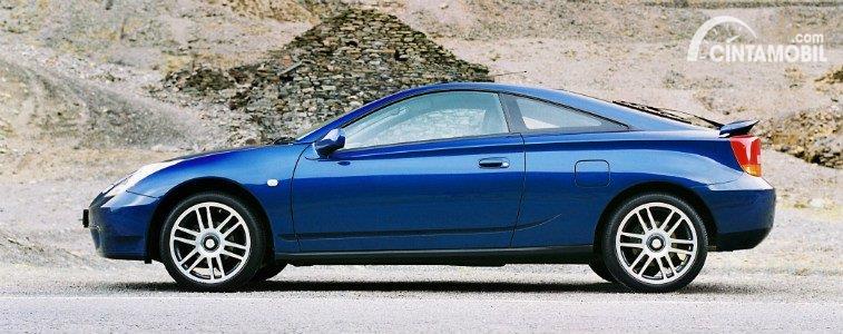 Gambar menunjukkan sebuah mobil Toyota Celica berwarna biru dilihat dari sisi samping