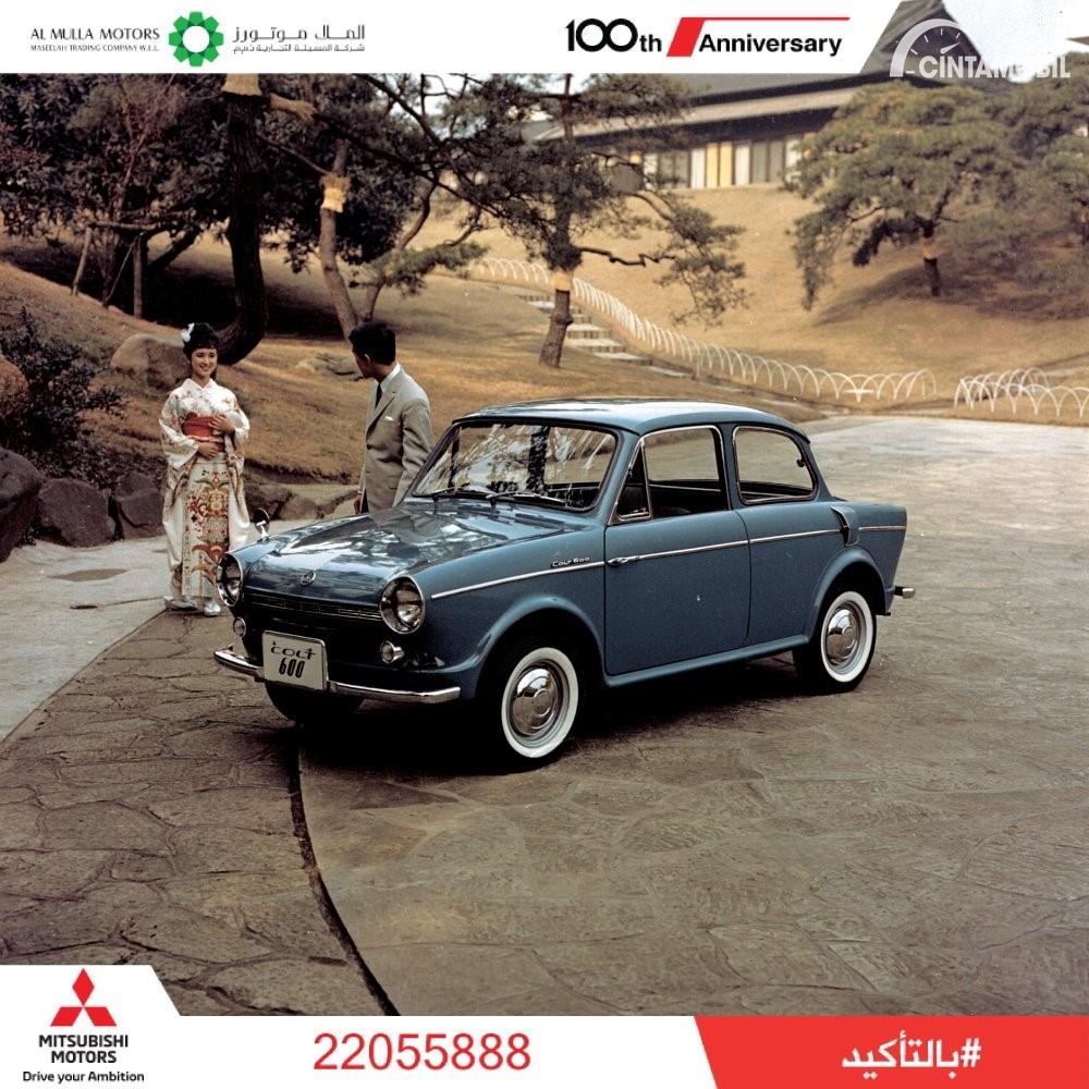 Gambar menunjukkan sebuah mobil Mitsubishi Colt 1962 berwarna biru dilihat dari sisi depan