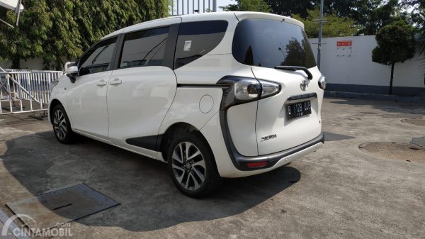 Gambar menunjukkan sebuah mobil Toyota Sienta 1.5 V MT 2016 berwarna putih dilihat dari sisi belakang